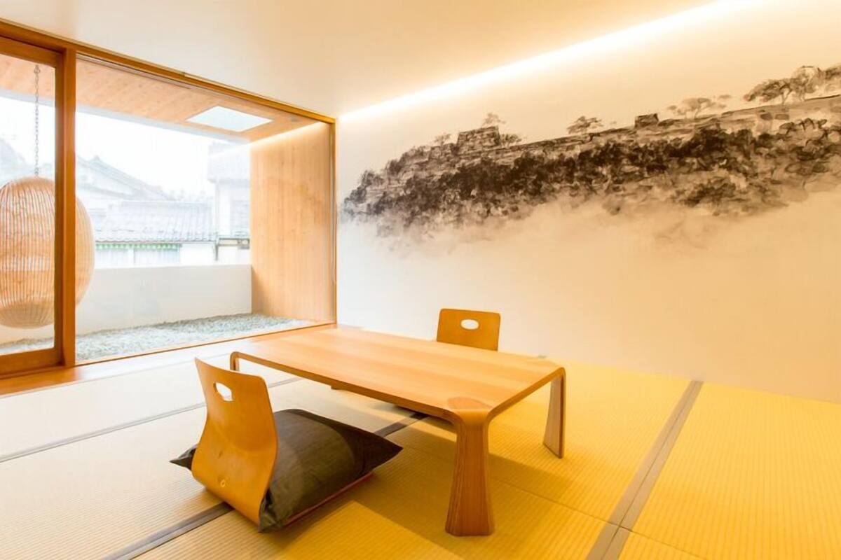 Een traditionele Japanse kamer met tatami vloerbedekking, een lage tafel en stoelen.
