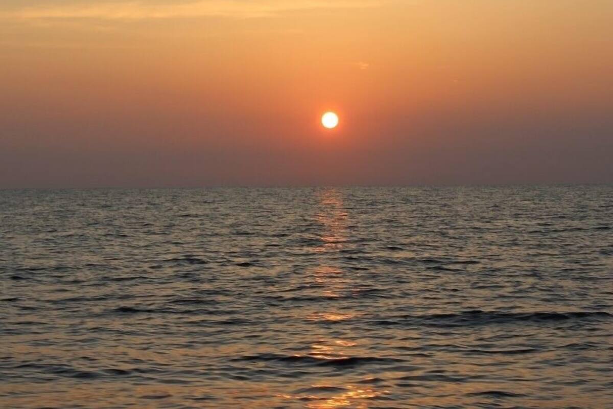 A sunset over a calm sea with no visible land or structures.