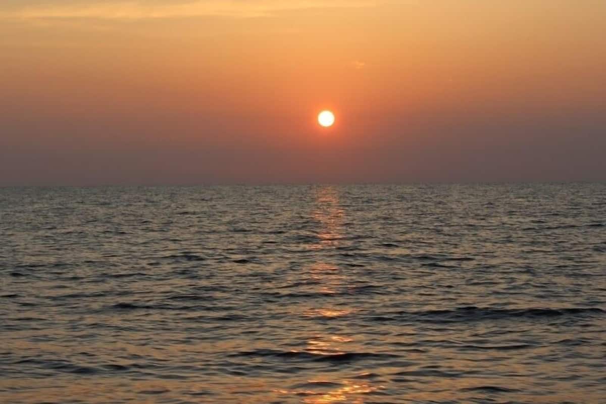 A sunset over a calm sea with no visible land or structures.