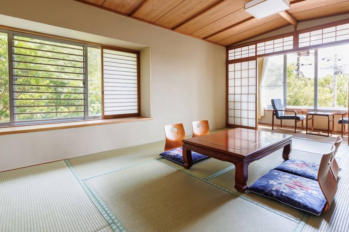 A traditional Japanese room with tatami flooring, a low wooden table, and sliding doors.