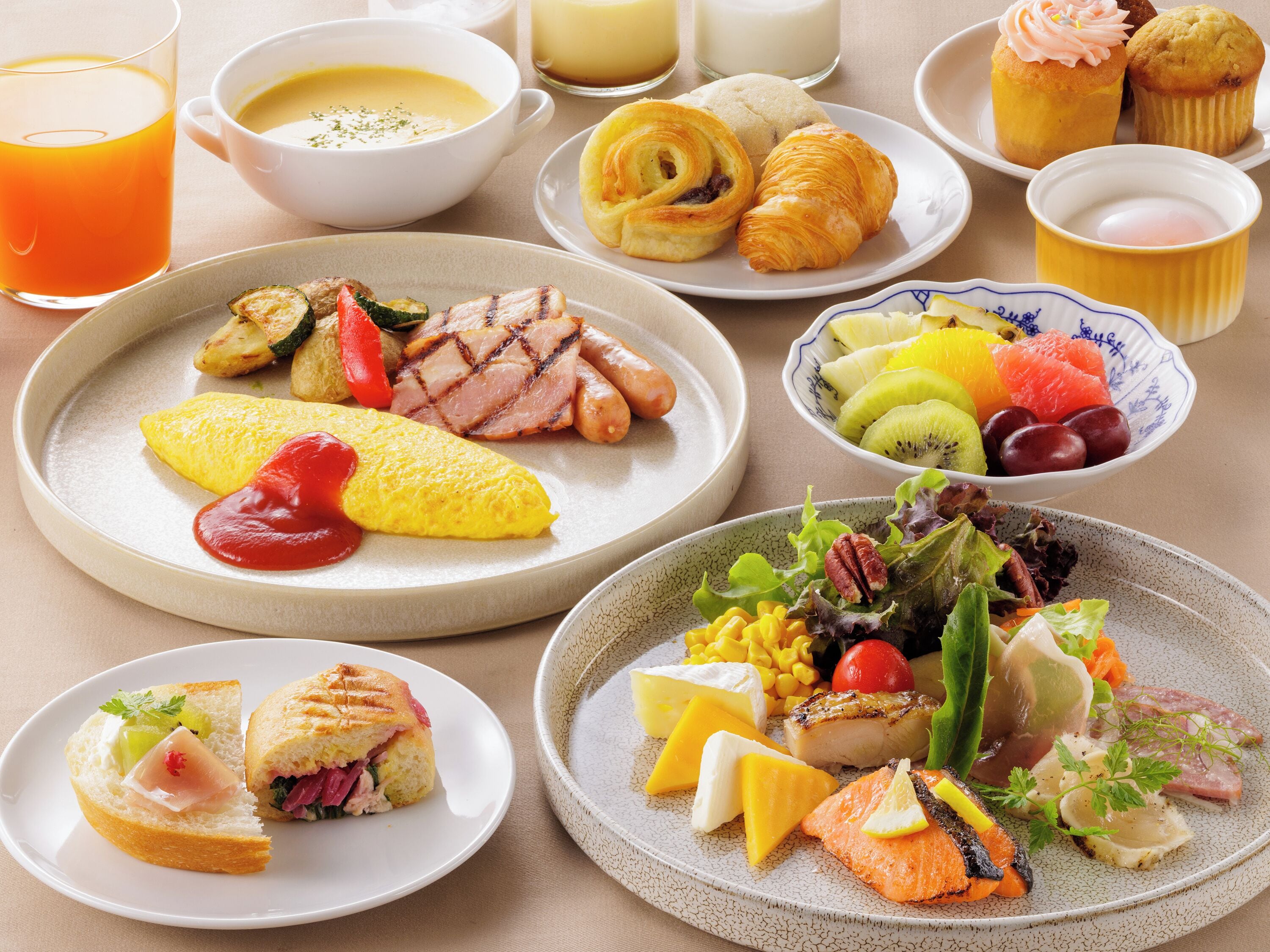 A variety of breakfast dishes including eggs, meats, and pastries on plates.