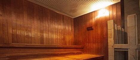 Una sauna de madera con escalones y un banco, con techo de azulejos y una ventana con cortinas.