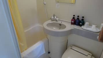 A bathroom with a sink, toilet, and bathtub. There are toiletries on the sink counter.