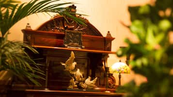 Un mueble de madera con una escultura decorativa de un pájaro y un cuadro enmarco.