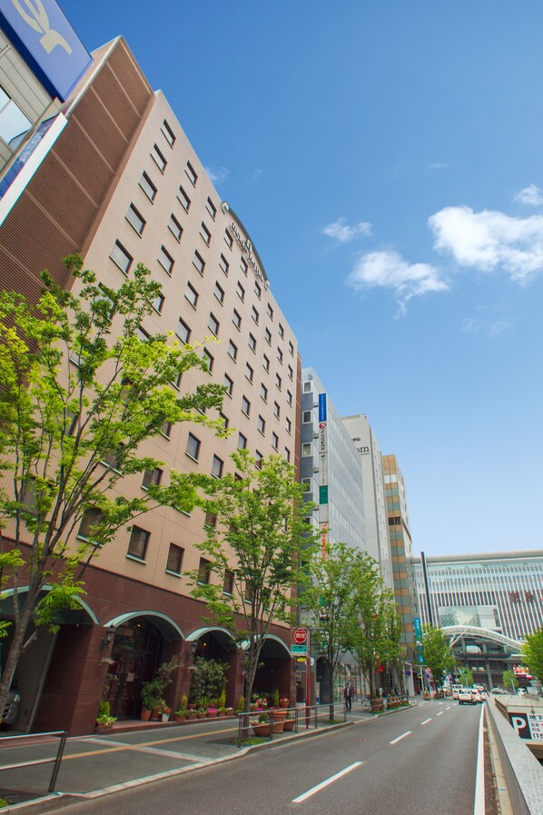 A multi-story hotel with a modern facade, large windows, and a prominent entrance with a covered area. - Dukes Hotel Hakata (Fukuoka)