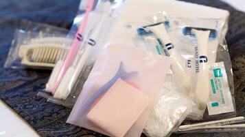 A collection of toiletries including a toothbrush, razor, and shaving cream in plastic bags.