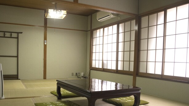 A traditional Japanese room with tatami flooring, a low wooden table, and shoji screens. - Yamabe Hotel (Tenri)