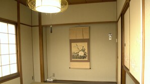 A traditional Japanese room with tatami flooring, a shoji screen, and a hanging lamp. - Yamabe Hotel (Tenri)