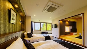 Une chambre d’hôtel avec deux lits, un grand miroir, une télévision et une vue sur les arbres par la fenêtre.