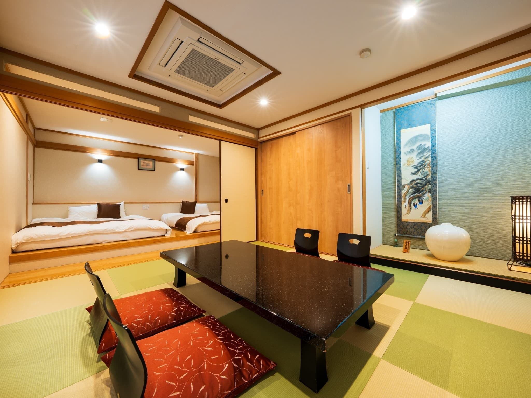 Habitación de hotel con cama, una mesa de comedor con sillas, un ventanal con vistas y un ventilador de techo.