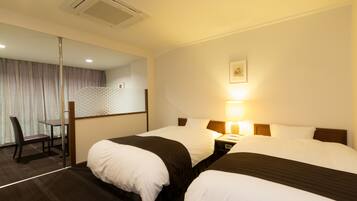 A hotel room with two beds, a desk, and a chair.