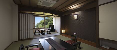 Una habitación tradicional japonesa con suelo de tatami, una mesa baja y cojines.