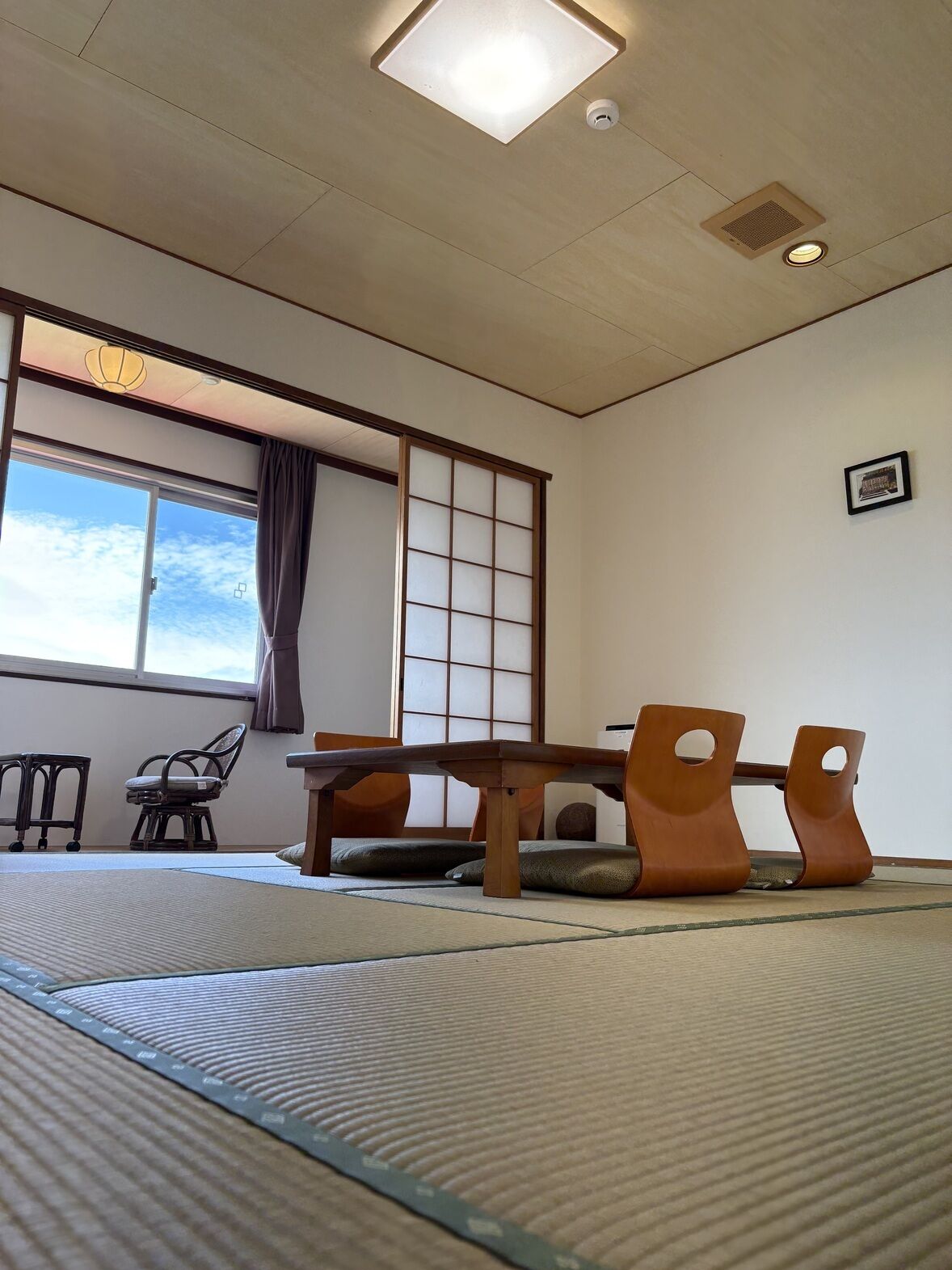 Perinteinen japanilainen huone, jossa on tatamimatto, matala pöytä ja liukuva shoji-seinä.