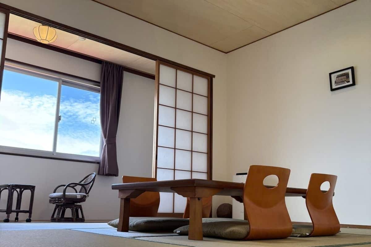 Ein traditioneller japanischer Raum mit Tatami-Böden, einem niedrigen Tisch und einer verschiebbaren Shoji-Trennwand.