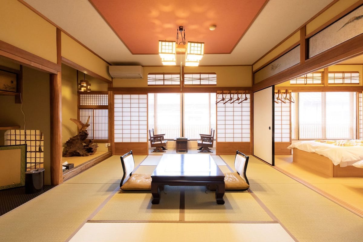 Une pièce de style japonais traditionnel, avec un sol recouvert de tatamis, une table basse et des portes coulissantes.