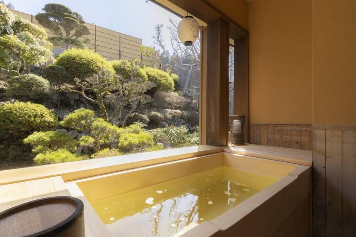 Un bain japonais traditionnel avec vue sur un jardin aménagé.