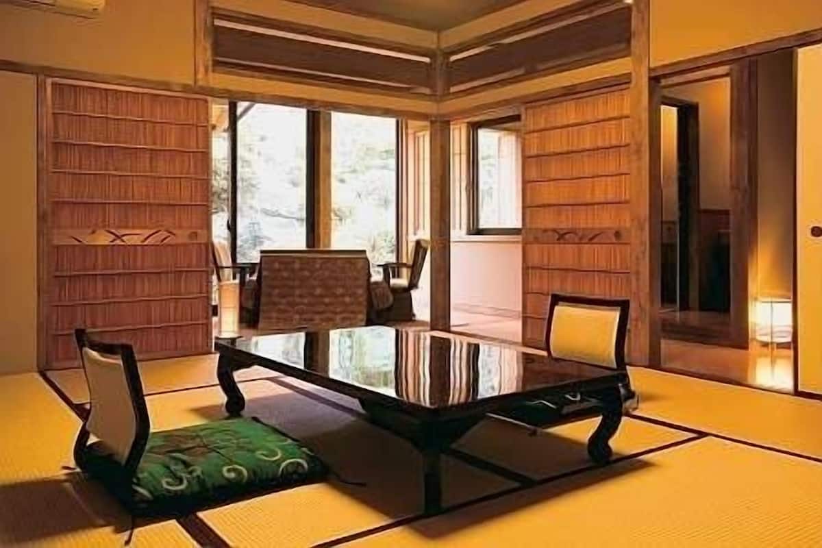 Une pièce de style japonais traditionnel, avec un sol recouvert de tatamis, une table basse et des chaises.