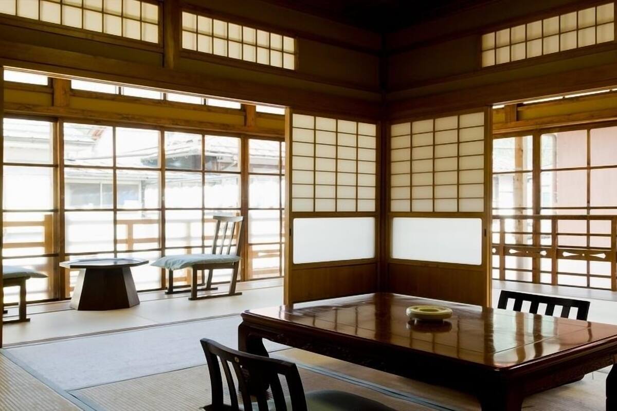 Une pièce de style japonais traditionnel, avec un sol recouvert de tatamis, une table basse et des portes coulissantes.
