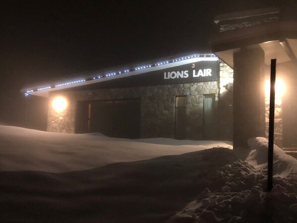 A Lions Lounge with stone walls and a sign, surrounded by snow. - The Lions Lair (Smiggin Holes)
