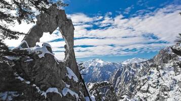 Un paisaje montañoso y agreste con picos nevados y un cielo despejado.