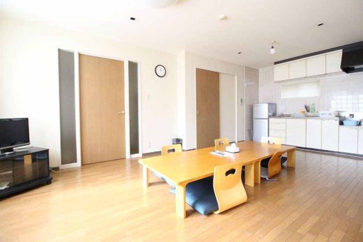 Een moderne keuken met witte kasten en een houten eettafel.