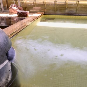 Une piscine avec une terrasse en bois et un grand objet gonflable.