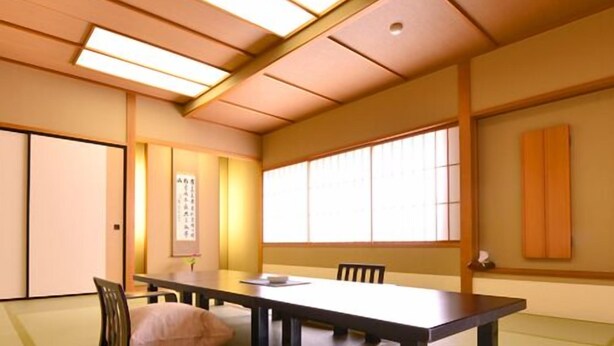 Et traditionelt japansk værelse med tatamimåtter, et lavt bord og skydedøre.
