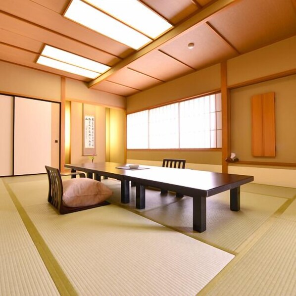 A traditional Japanese-style room with tatami flooring, a low table, and sliding doors.