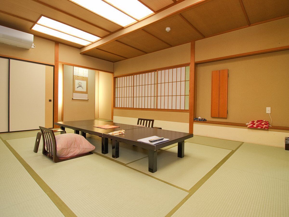 Habitació tradicional japonesa amb tatamis, una taula baixa i portes corredisses.