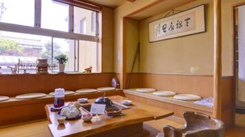 Ein traditioneller japanischer Raum mit Tatami-Boden, einem niedrigen Tisch mit Teeutensilien und einem Shoji-Bildschirm.