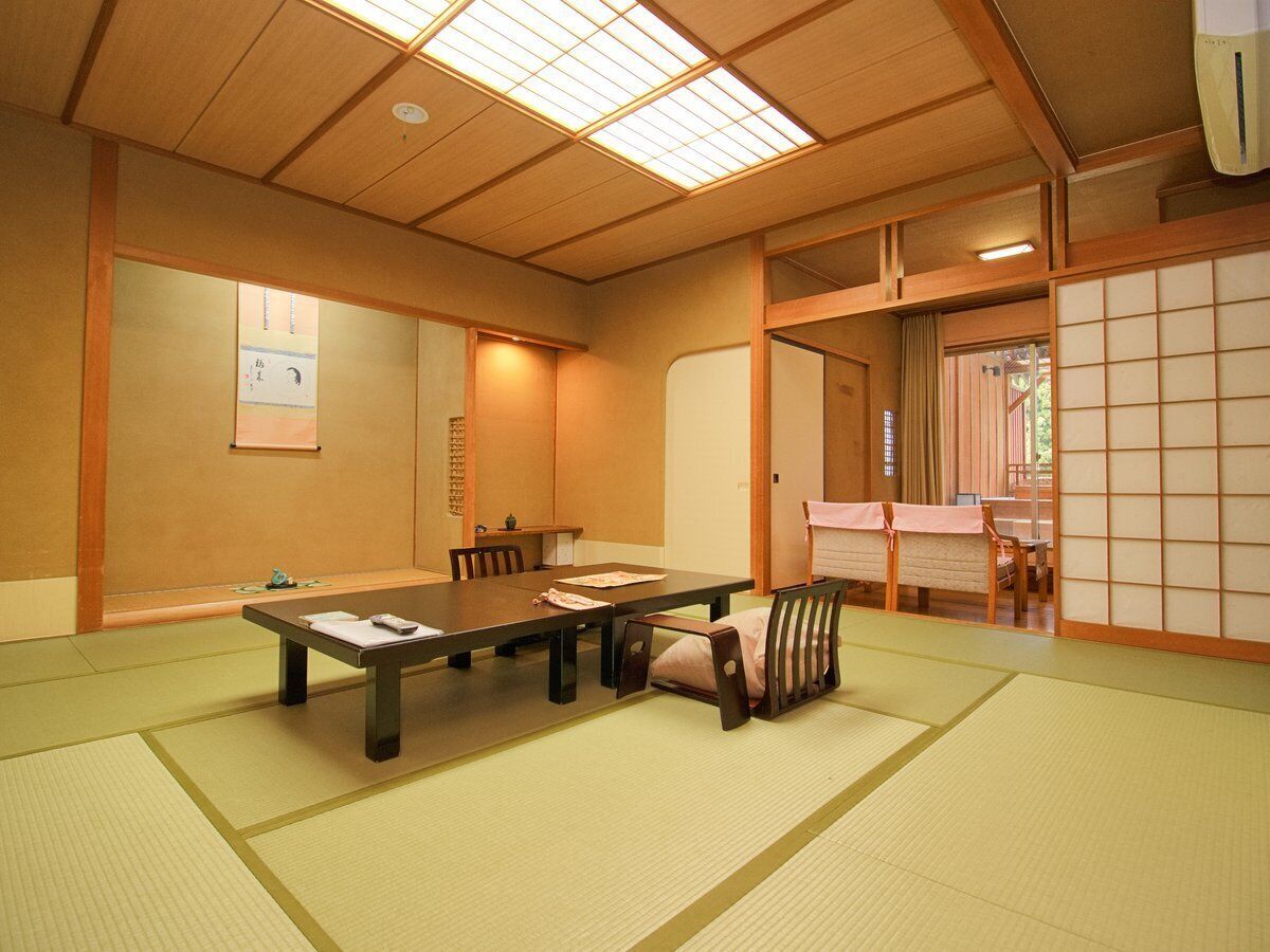 Una habitació japonesa tradicional amb tatamis, una taula baixa i portes corredisses.