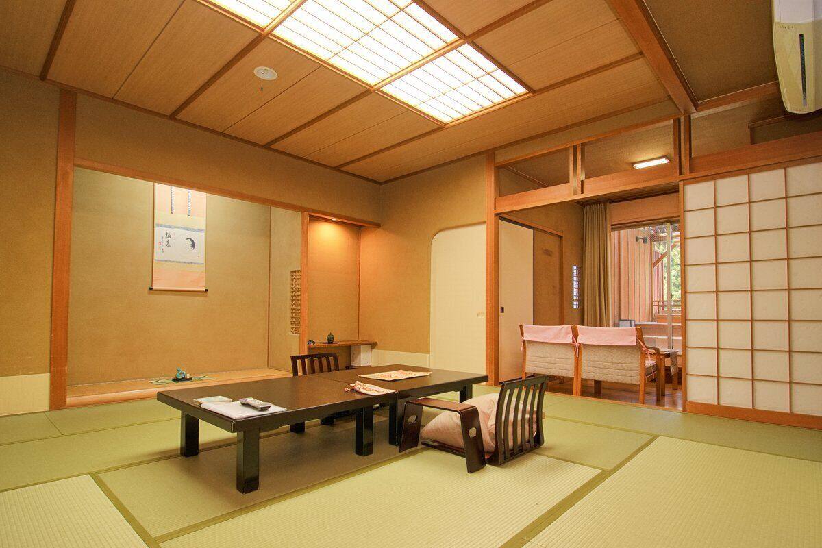 Ein traditioneller japanischer Raum mit Tatami-Böden, einem niedrigen Tisch und Schiebetüren.