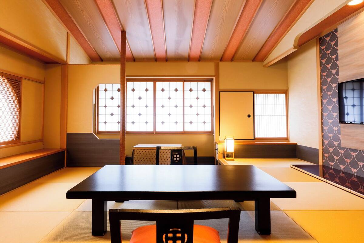 A traditional Japanese room with tatami flooring, a low table, and sliding doors.