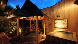 Un área de spa de madera con un jacuzzi y una estructura cubierta de madera.