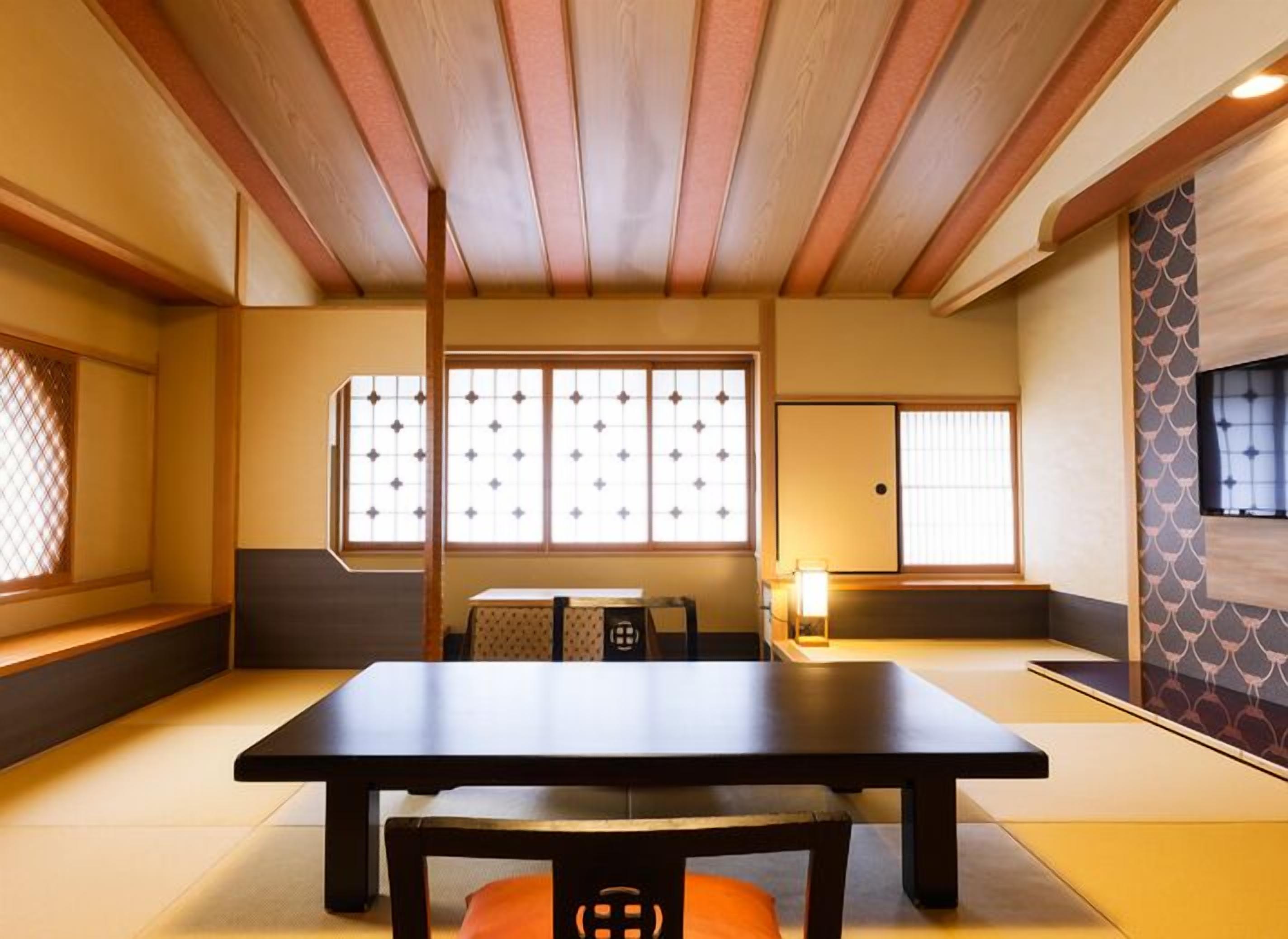 A traditional Japanese room with tatami flooring, a low table, and sliding doors.