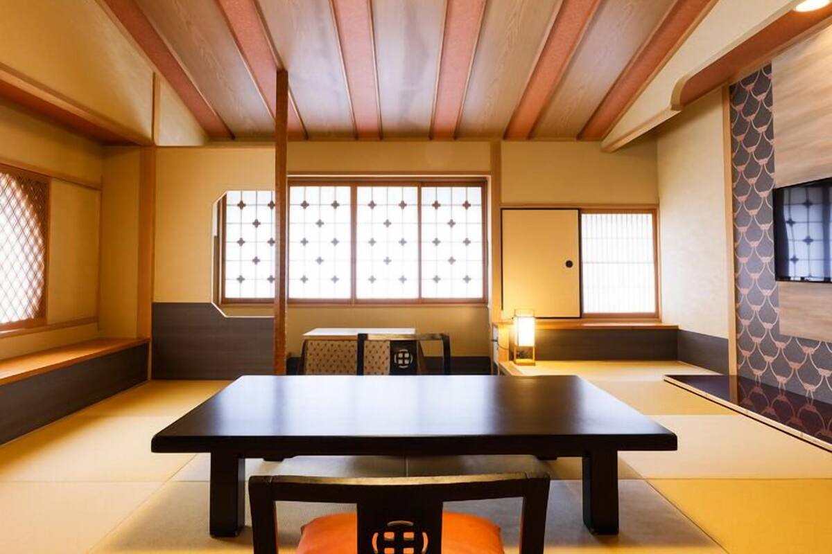A traditional Japanese room with tatami flooring, a low table, and sliding doors.