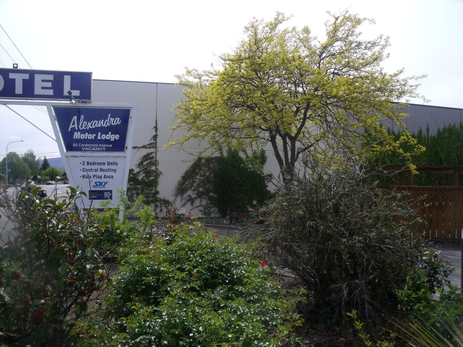 Señal del Alexander Motor Lodge, que indica habitaciones de dos dormitorios, calefacción central y zona de juegos para niños.