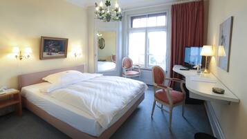 Une chambre d’hôtel équipée d’un lit, d’un bureau, d’une chaise et d’un téléviseur.