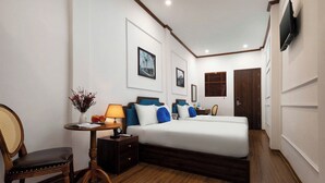 A hotel room with a bed, bedside table, lamp, chair, and wall-mounted TV.