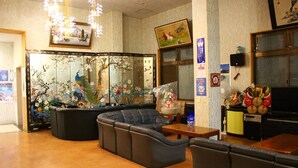 A traditional room with tatami flooring, a low table, a sofa, and a decorative screen with artwork. - Shirahama Onsen Minshuku A Course (Shirahama)