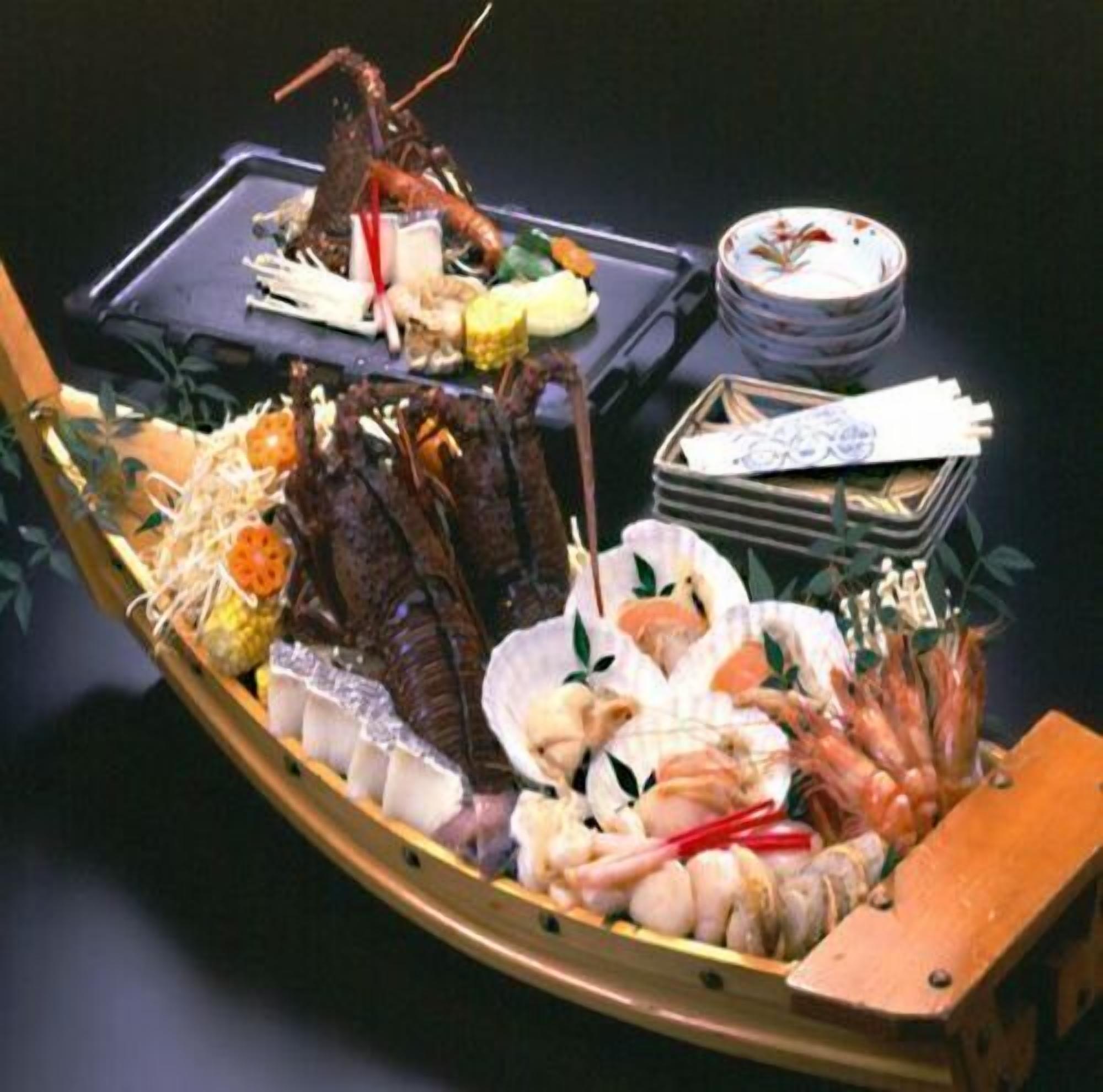 Un plateau de fruits de mer comprenant différents types de fruits de mer, notamment des crevettes et du homard, disposés sur un plateau en forme de bateau en bois.