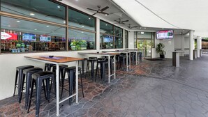 A modern restaurant with high ceilings, ceiling fans, and a stone-tiled floor. - Cannonvale Reef Gateway Hotel (Cannonvale)