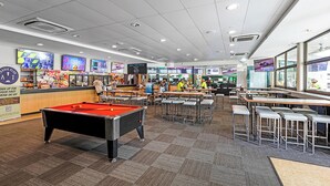 A billiards table, multiple bar stools, and a counter area with a menu display in a casual dining setting. - Cannonvale Reef Gateway Hotel (Cannonvale)