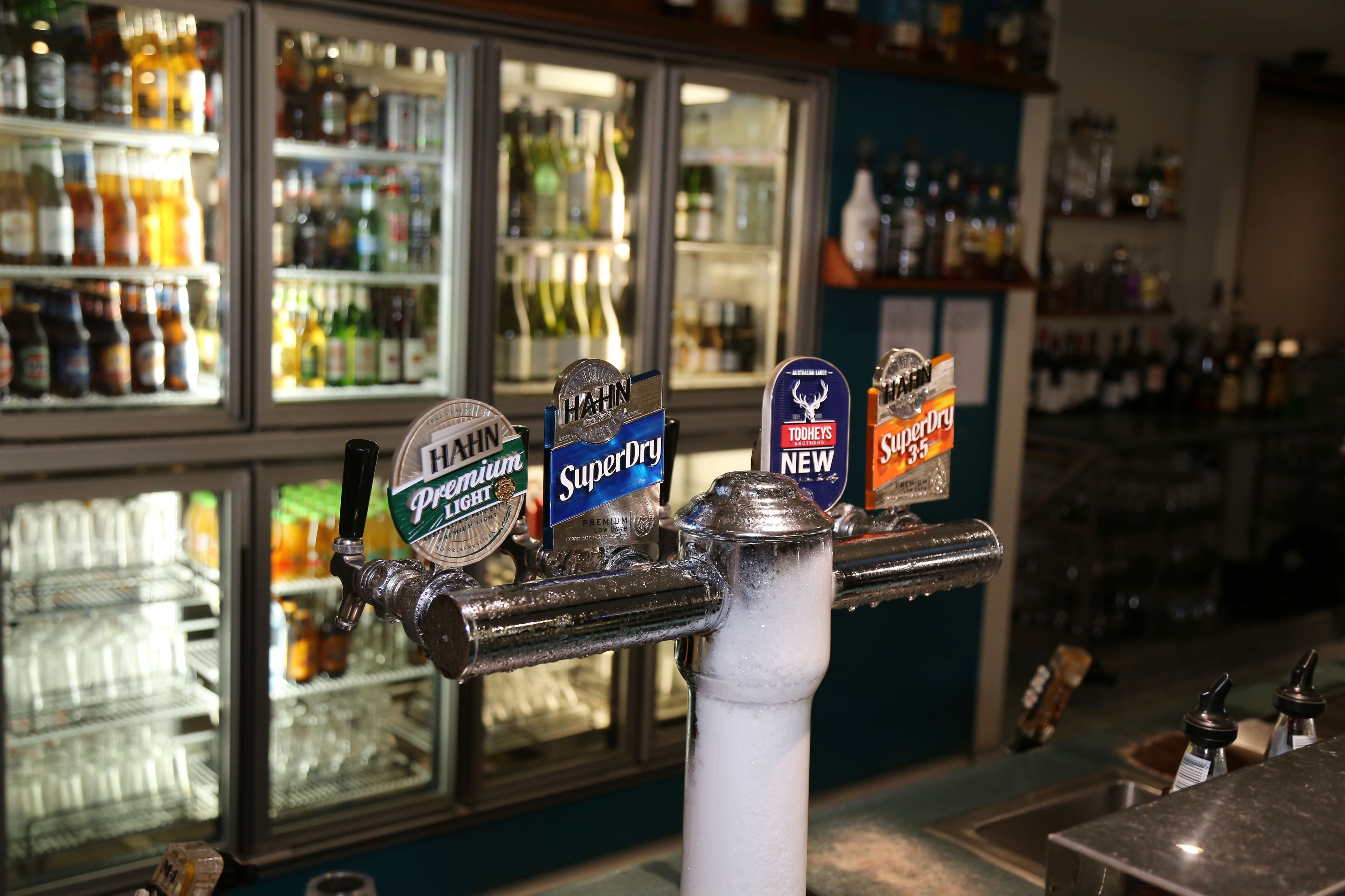 A bar with multiple taps labeled with beer brands.