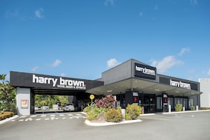Una tienda Harry Brown de vinos, cervezas y licores con un diseño moderno, que cuenta con una entrada despejada y un cartel.