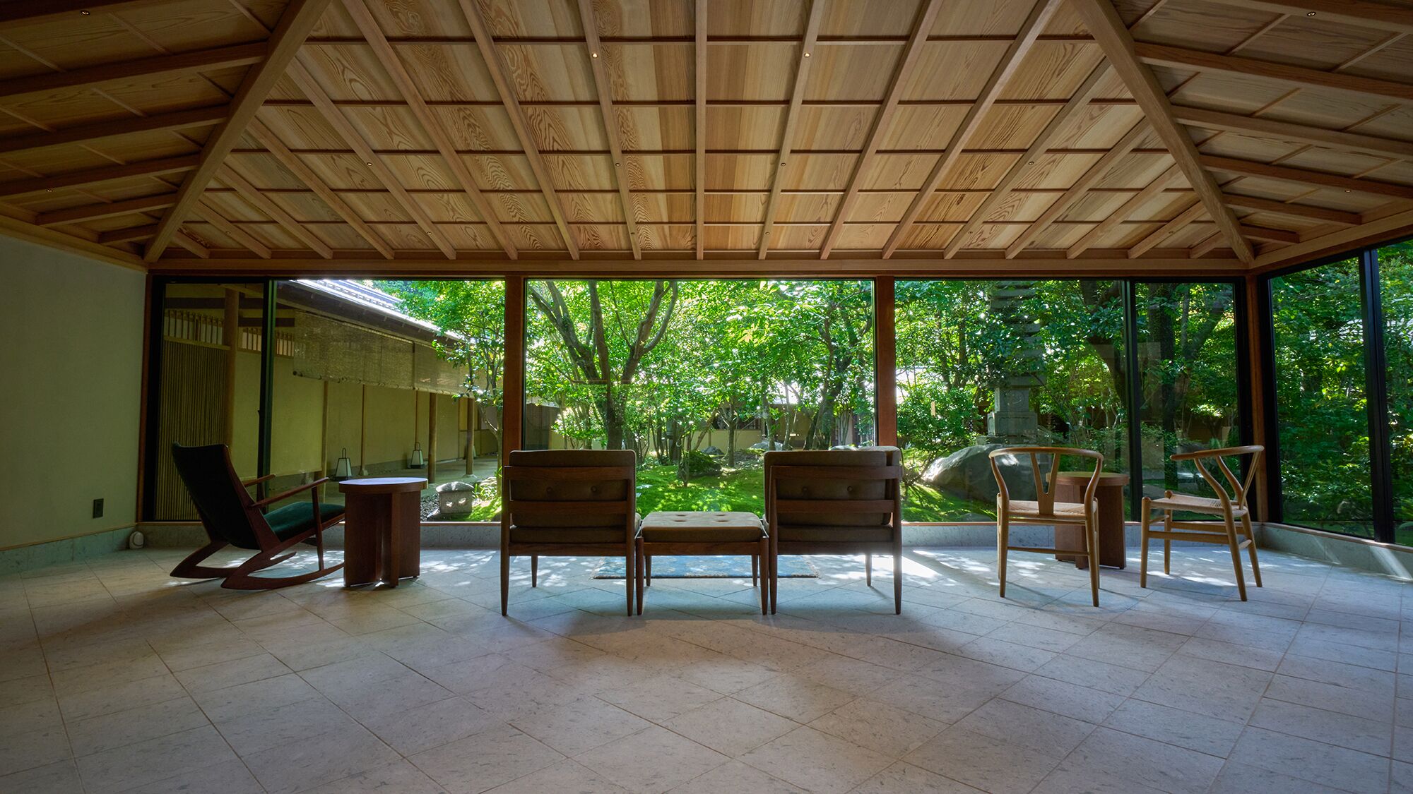 A spacious room with a high ceiling, large windows, and a view of a lush garden.