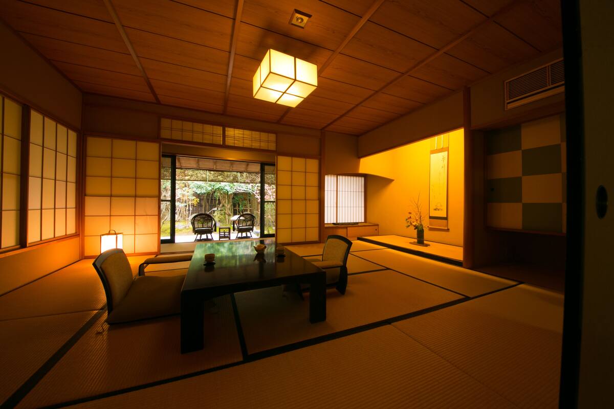 A traditional Japanese room with tatami flooring, a low table, and shoji screens.