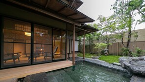 A traditional Japanese-style building with a koi pond, wooden deck, and a view of the garden. - Yakakutei (Kirishima)