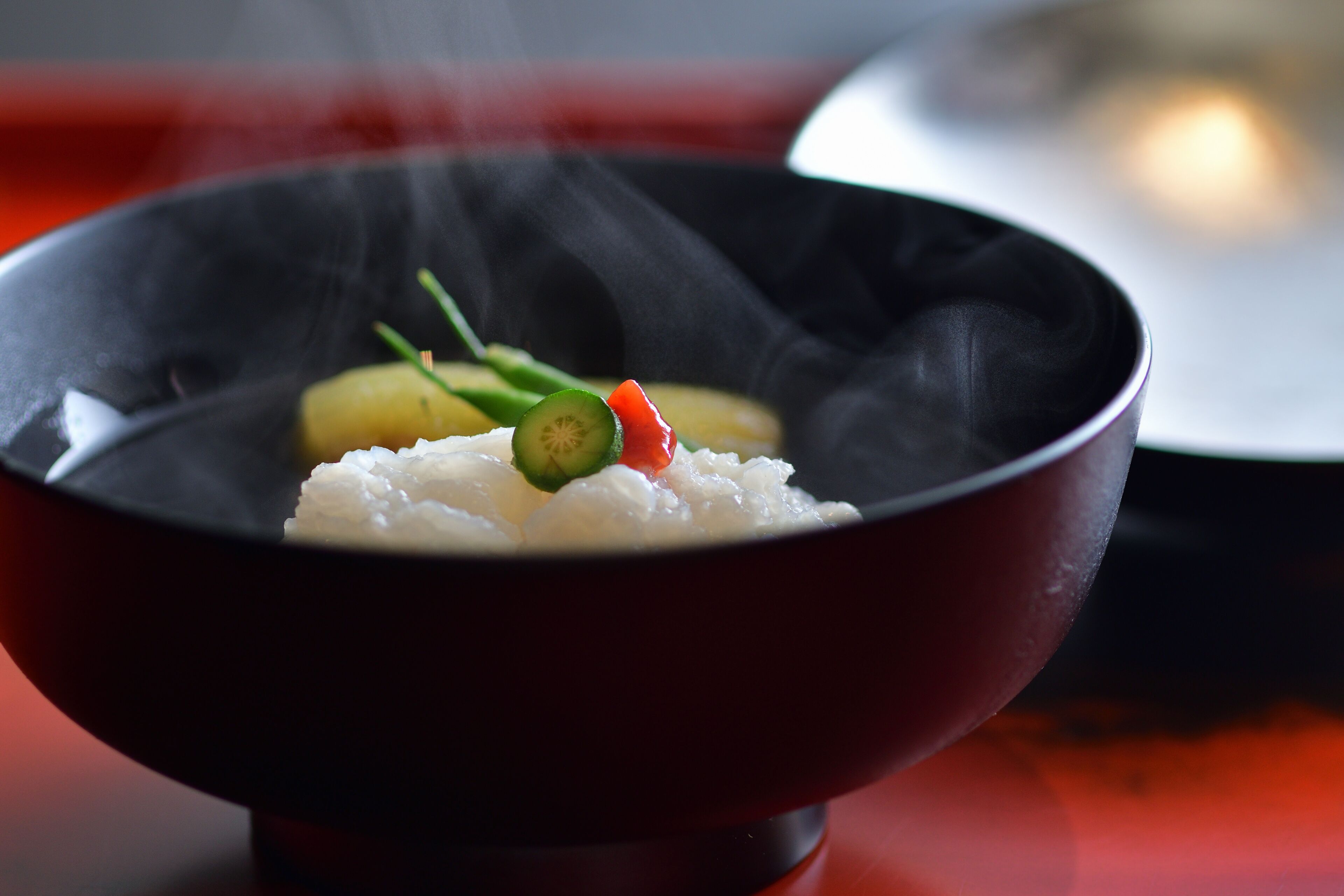 A bowl of rice with vegetables on a table.
