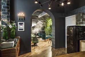 A modern interior with a wooden reception desk, a green seating area, and a visible staircase. - G-Rough, Rome, a Member of Design Hotels (Rome)